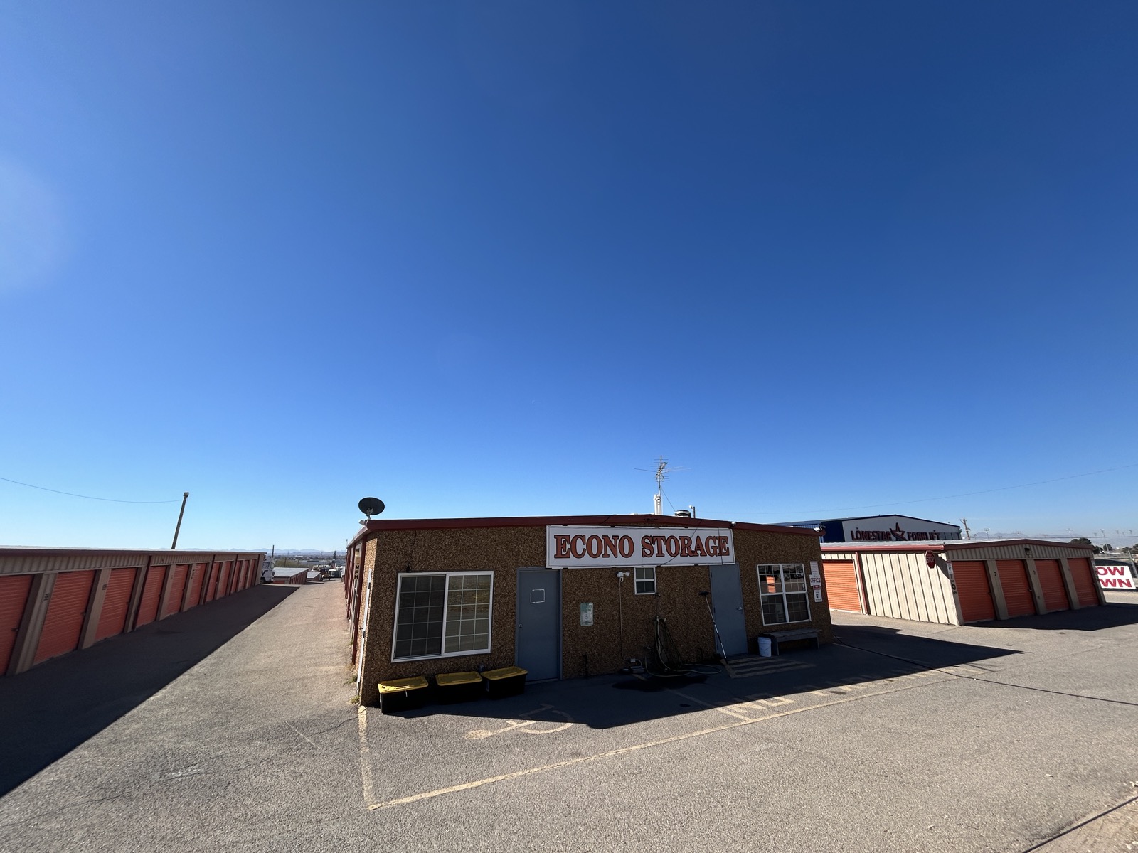 Econo Storage office and facility exterior with storage units on both sides